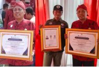 Foto: Kades Sapeken Terima Penghargaan Juara I Desa Prospektif Good Govermance Pengelolaan Keuangan Desa Tahun 2023 yang dierahkan langsung oleh Bupati secara simbolis (kiri) , 2 perangkat desa Sapeken tampak bangga memegang 2 sertifikat penghargaan desanya (kanan) 
