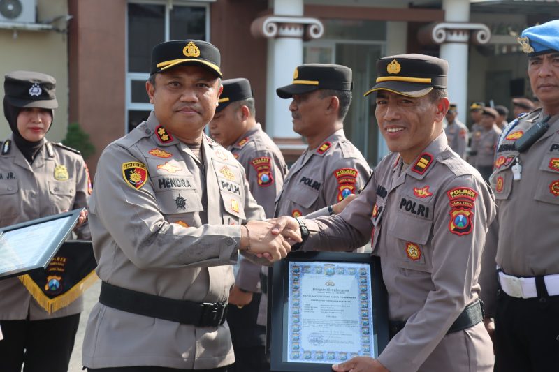 Kapolres Pamekasan AKBP Hendra Eko Triyulianto menyerahkan piagam penghargaan kepada Iptu Nanang saat apel yang digelar di Halaman Mapolres setempat, Senin (17 Maret 2025) 