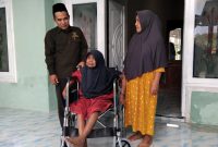 Foto : Didampingi keluarga dan ketua BAZNAS Ahmad Rahman, Mbah Sawiya, tersenyum bahagia menerima bantuan kursi roda 