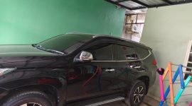 Foto kendaraan roda 4 jenis pajero sport nomor polisi DD 101  di halaman rumah  T saat setelah menerima gadai dari E