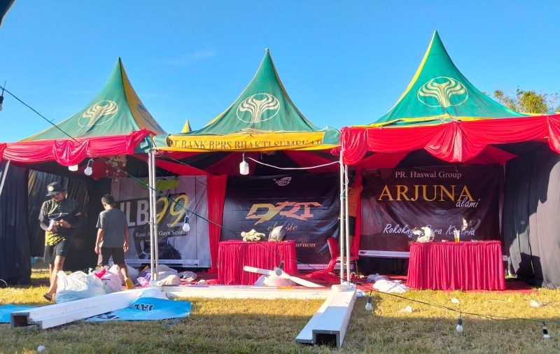 Pekerja tengah mempersiapkan dekorasi stand dengan penuh semangat
