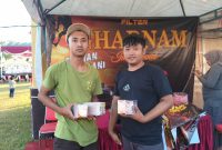Dua pekerja PR Mulia Indah, memperlihatkan bukti produk HM Cokelat dan Rokok SKT-SKM Gharnam di stand Festival Tembakau Madura 2025. Aksi ini menegaskan kualitas dan keaslian produk lokal yang siap bersaing di pasar nasional