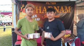 Dua pekerja PR Mulia Indah, memperlihatkan bukti produk HM Cokelat dan Rokok SKT-SKM Gharnam di stand Festival Tembakau Madura 2025. Aksi ini menegaskan kualitas dan keaslian produk lokal yang siap bersaing di pasar nasional