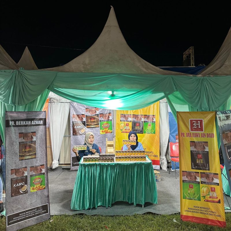 Keterangan Foto:
Karyawan PR Dua Hawa Bin Daud di stand Festival Tembakau Madura 2025, sambil memamerkan varian SKT Ha’il Original, Ha’il Teh, dan Ha’il Mangga. Kehadiran mereka tidak hanya menampilkan produk, tetapi juga menjadi simbol peran industri kretek dalam membuka lapangan kerja dan menopang kesejahteraan masyarakat lokal.