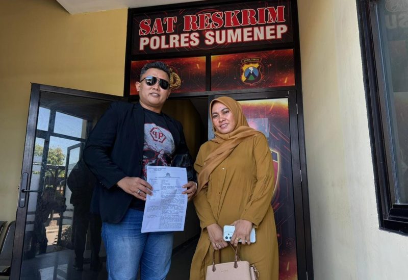 Pengacara  Angga Kurniawan, S.H, M.H dan Hj. Yulianah (pelapor) berdiri bersama di depan Mapolres Sumenep setelah resmi melaporkan akun TikTok yang diduga mencemarkan nama baik .
