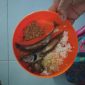 Dua siswa SDN Pabian IV tampak membawa pulang lauk ikan pindang dan tempe usai jam makan siang, Kamis (30/12/2025). Menu Program Makan Bergizi (MBG) hari itu dikeluhkan karena dinilai kurang layak dan tidak diminati anak-anak.
