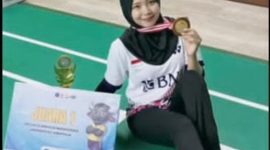 Puput, mahasiswa asal Manding Laok, berpose dengan trofi juara 1 bulu tangkis