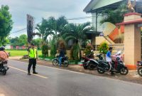 Aipda Agus Junaidi sigap membantu siswa SDN Manding Laok I menyeberang jalan dengan aman, setiap pagi, menunjukkan pengabdian nyata polisi untuk keselamatan anak-anak
