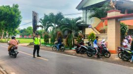 Aipda Agus Junaidi sigap membantu siswa SDN Manding Laok I menyeberang jalan dengan aman, setiap pagi, menunjukkan pengabdian nyata polisi untuk keselamatan anak-anak
