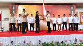 Moch Wijdan menerima bendera pataka PKDI dari Ketua PKDI Jawa Timur, Syaifullah Mahdi, saat dikukuhkan sebagai Ketua PKDI Madura Raya di Sampang (26/11/2025). Pelantikan ini menandai langkah baru konsolidasi kepala desa se-Madura.
