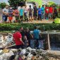 Anggota JSI, DLH, dan PKDI bahu-membahu membersihkan area rawan sampah sebagai bentuk kampanye kepedulian lingkungan.