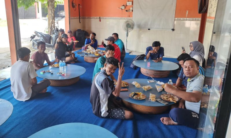 Anggota Jurnalis Sumenep Independen dan Pasukan Kuning DLH Sumenep menikmati makan bersama usai aksi bersih-bersih, simbol kebersamaan dan kepedulian terhadap lingkungan.
