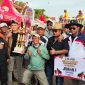 H. Fathor Rosi bersama timnya berpose dengan piala juara pertama Kerapan Sapi Kapolres Sumenep Cup 2025 di Lapangan Kerapan Sapi Sumenep.