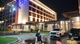 Tampak depan Hotel Myze Sumenep dari area parkir, menampilkan fasad modern dan akses mudah bagi tamu yang datang.