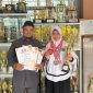 AZ Syahra Nastiti Ramadhani didampingi Kepsek Muhlisari S.Pd menunjukkan piagam dan piala prestasi setelah meraih juara 2 Mapel Matematika se-Madura dalam Lomba Matematika GCO 2026, membuktikan kerja keras dan dedikasinya dalam mengembangkan potensi akademik.