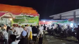 Petugas Madas Sedarah DPC Sampang menyajikan kopi, teh, dan air gratis bagi jamaah Haul Ponpes Darul Ulum.