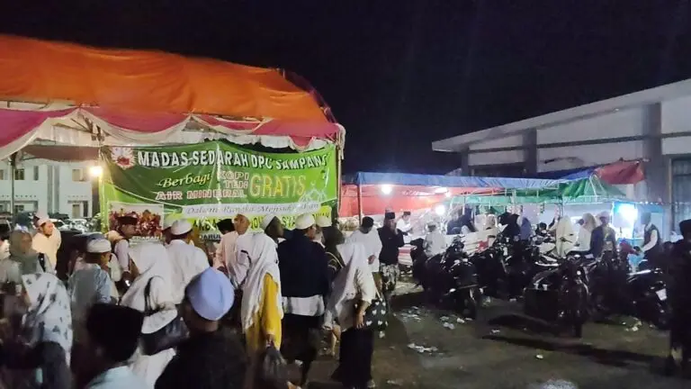 Petugas Madas Sedarah DPC Sampang menyajikan kopi, teh, dan air gratis bagi jamaah Haul Ponpes Darul Ulum.