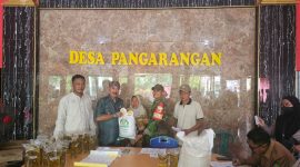 Kades Pangarangan, Miskun Legiyono, saat menyerahkan bantuan beras dan Minyak Kita kepada warga penerima manfaat.