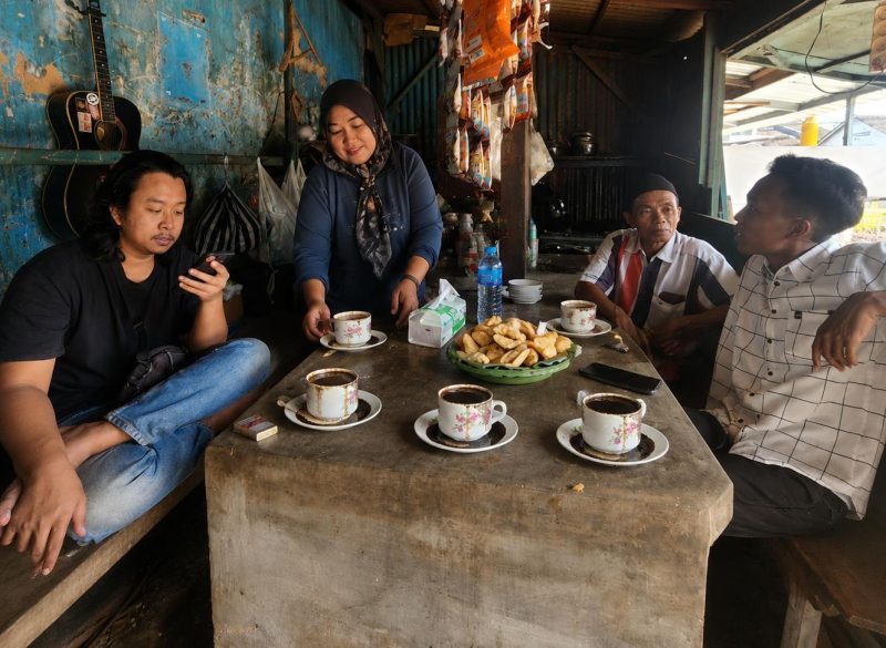 Suasana hangat di Warung Kopi Peceng, Jalan Raya Gedungan, Kecamatan Batuan, Sumenep. Warung kopi legendaris yang berada di depan Dealer Honda Sinar Baru ini menjadi tempat berkumpul berbagai kalangan, dari pejabat hingga masyarakat biasa, dalam suasana penuh keakraban dan kebersamaan.