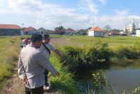 Petugas Polres Sampang menunjukkan lokasi embung air di Dusun Sabu'uk, Desa Junok, Kecamatan Sreseh, tempat tiga balita saudara kandung ditemukan meninggal dunia akibat tenggelam, Minggu (14/6/2026). (Foto: Humas Polres Sampang for Detikzone.id)