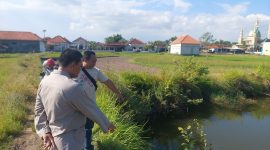 Petugas Polres Sampang menunjukkan lokasi embung air di Dusun Sabu'uk, Desa Junok, Kecamatan Sreseh, tempat tiga balita saudara kandung ditemukan meninggal dunia akibat tenggelam, Minggu (14/6/2026). (Foto: Humas Polres Sampang for Detikzone.id)