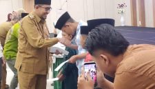 Bupati Sumenep Achmad Fauzi Wongsojudo saat menyerahkan santunan kepada anak yatim, menegaskan pentingnya menjadikan Muharram sebagai momentum memperkuat kepedulian dan kesalehan sosial.