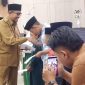 Bupati Sumenep Achmad Fauzi Wongsojudo saat menyerahkan santunan kepada anak yatim, menegaskan pentingnya menjadikan Muharram sebagai momentum memperkuat kepedulian dan kesalehan sosial.