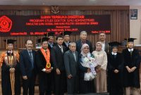 MOMEN BAHAGIA: Dr. Sri Roekminiati (tengah, memegang bunga) berfoto bersama setelah dinyatakan lulus dalam Ujian Terbuka Program Doktor Ilmu Administrasi di Universitas Jember, Jember, 17 Juni 2026. (Foto: Ardi)