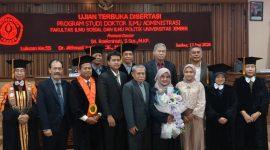 MOMEN BAHAGIA: Dr. Sri Roekminiati (tengah, memegang bunga) berfoto bersama setelah dinyatakan lulus dalam Ujian Terbuka Program Doktor Ilmu Administrasi di Universitas Jember, Jember, 17 Juni 2026. (Foto: Ardi)