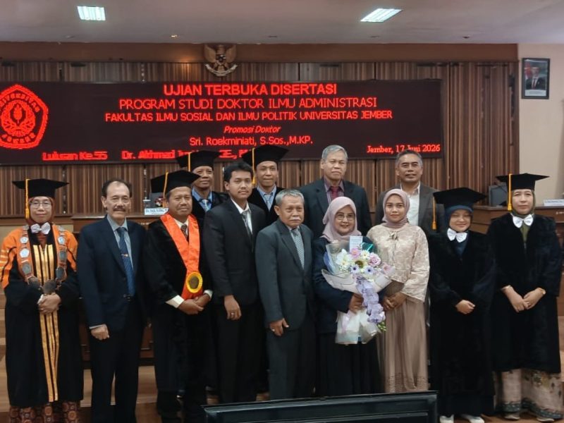 MOMEN BAHAGIA: Dr. Sri Roekminiati (tengah, memegang bunga) berfoto bersama setelah dinyatakan lulus dalam Ujian Terbuka Program Doktor Ilmu Administrasi di Universitas Jember, Jember, 17 Juni 2026. (Foto: Ardi)