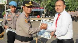 Kapolres Sampang AKBP Hartono menyerahkan penghargaan kepada Kasatreskrim Iptu Nur Fajri Alim atas keberhasilan mengungkap 27 kasus asusila terhadap anak dan sindikat curanmor di 31 TKP saat upacara di Mapolres Sampang, Rabu (15/7/2026).