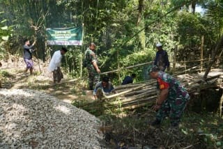 Foto: Babinsa Koramil 0827/16 Gapura Koptu Lucky Vecky Tania bersama warga bergotong royong membersihkan area Jembatan Kadhempol di Desa Palo'lo'an, Kecamatan Gapura, sebagai persiapan pembangunan jembatan beton melalui Program Karya Bakti Skala Besar TNI AD Wilayah Madura.