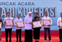 Gubernur Jawa Timur Khofifah Indar Parawansa (tengah) menyerahkan Piagam Penghargaan Dharma Bakti Koperasi Jawa Timur kepada Rektor Universitas Dr. Soetomo (Unitomo), Prof. Dr. Siti Marwiyah, S.H., M.H. (ketiga kanan), pada Puncak Peringatan Hari Koperasi ke-79 Provinsi Jawa Timur di Pemakasan, Minggu (26/7/2026).