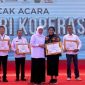 Gubernur Jawa Timur Khofifah Indar Parawansa (tengah) menyerahkan Piagam Penghargaan Dharma Bakti Koperasi Jawa Timur kepada Rektor Universitas Dr. Soetomo (Unitomo), Prof. Dr. Siti Marwiyah, S.H., M.H. (ketiga kanan), pada Puncak Peringatan Hari Koperasi ke-79 Provinsi Jawa Timur di Pemakasan, Minggu (26/7/2026).