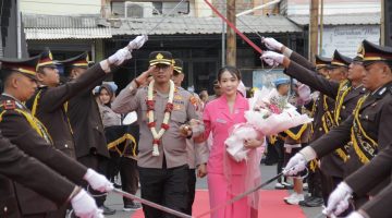 AKBP Anang Hardiyanto, S.I.K., didampingi Ketua Bhayangkari Cabang Sampang, Ny. Rr. Willa Anang, memasuki gerbang kehormatan melalui tradisi Pedang Pora saat penyambutan resmi sebagai Kapolres Sampang di Mapolres Sampang, Rabu (29/7/2026).
