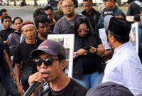 Imron Muslim, Sekretaris Jenderal Persatuan Jurnalis Sampang (PJS), menyampaikan orasi saat aksi damai gabungan organisasi wartawan di depan Kantor DPRD Sampang, Jumat (31/7/2026).