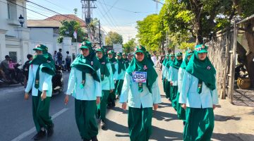 Caption: Peserta Gerak Jalan SMPN 1 Sampang Nomor Urut 85 Regu Putri (Sumber Foto: Agus Junaidi/Detikzone.id)