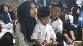 Ket foto: Seorang anak tampak tenang berada di pangkuan ibunya saat mengikuti peringatan Maulid Nabi Muhammad SAW di Majelis Dzikir Nurul Anwari, Kampung Mengoneng, Kelurahan Bojongbata, Pemalang.